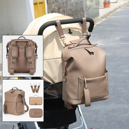 Sac a dos à langer couleur caramel accroché sur la poignée d'une poussette comprenant deux sangles, un porte-papier mouchoir et un kit de change rapide.