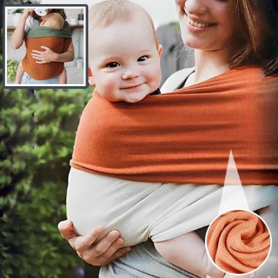 Porte bébé sling qui démontre un enfant qui sourit et qui est drôle.