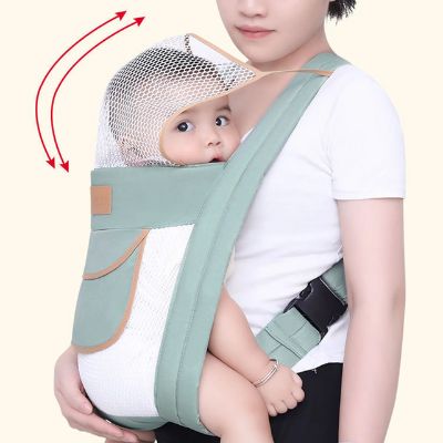 Ce porte bébé vert et blanc démontre un filet protecteur pour la tête de l'enfant.