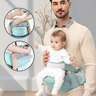 Porte bébé vert se portant à la taille avec son papa.