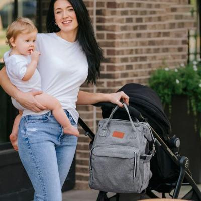 Sac à langer avec une maman heureuse et son enfant à l'extérieur.